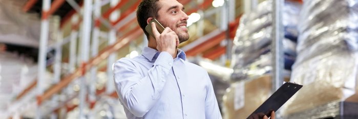 Mann telefoniert in Lagerhalle