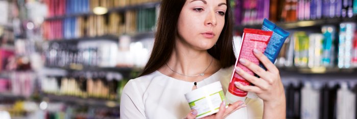 Frau mit Kosmetikprodukten und Verpackung in der Hand