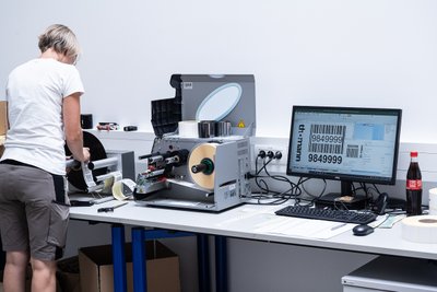 Mitarbeiterin an Barcode-Druckgerät